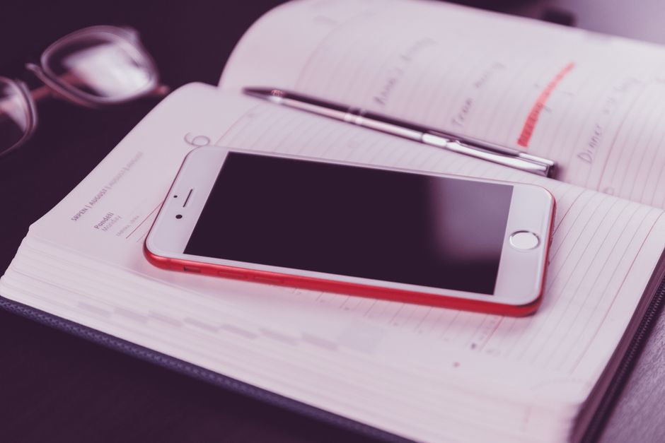 開いた手帳の上に置かれたスマートフォン