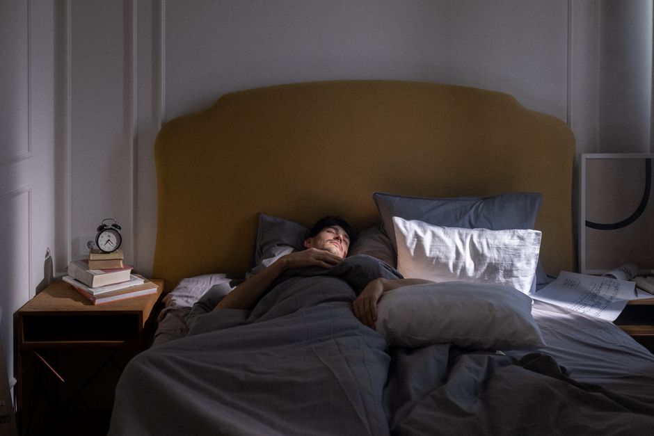 朝の光が差し込む寝室で眠っている人