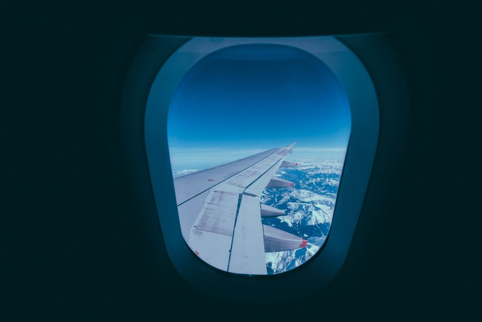飛行機の窓から見える主翼と雲海
